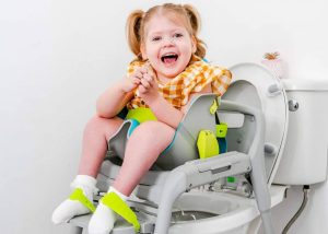 Enfant handicapé sur siège de toilette GottaGo dans une salle de bain